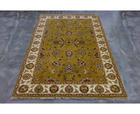 A KASHMIRI WOOL RUG (271 x 184cm)
Hand knotted wool with a mustard-yellow field featuring floral and vine motifs, surrounded 