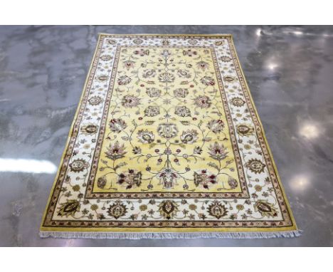 AN INDO KASHMIRI WOOL CARPET  (284 x 182cm)
Hand knotted wool pile with a pale yellow field with scrolling floral and vine mo