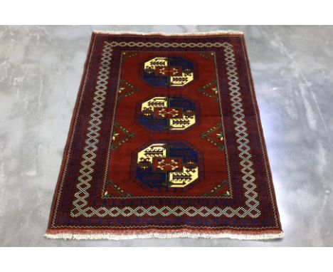 AN AFGHAN FIL POI WOOL RUG (174 x 125 cm)
Hand knotted wool pile featuring three prominent octagonal guls in the central fiel