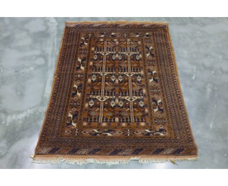 A FILPA WOOL RUG (182 x 114cm)
Hand knotted wool with a brown field featuring repeating geometric and tribal motifs, surround