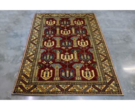 A KAZAK TRIBAL WOOL RUG (257 x 190cm)
Hand knotted wool with a red field, repeating tribal anchor motifs in ivory and navy, a