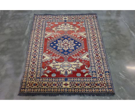 A KAZAK JOSHAGAN WOOL RUG (167 x 130cm)
Hand knotted wool, red field with a navy central medallion surrounded by geometric an