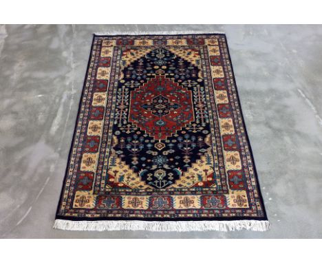 A KASHMIRI MEDALLION WOOL RUG 182 x 124
Hand knotted wool pile featuring a medallion design with intricate floral motifs, a d