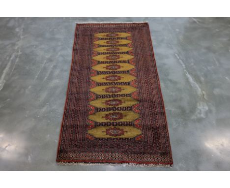 A PERSIAN BURHAN WOOL RUNNER (200 x 93cm)
Hand knotted wool pile with a camel ground featuring a central column of repeated o