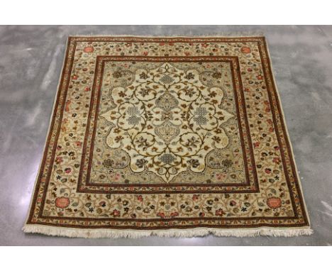 A SQUARE TABRIZ WOOL RUG (146 x 135cm)
Hand knotted wool, cream field with floral motifs in gold, brown, and pink, bordered b