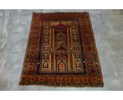 AN ANTIQUE PERSIAN MAJILIS RUG (140 x 100cm)
Hand knotted wool with a central mihrab design in muted red, brown, and gold ton