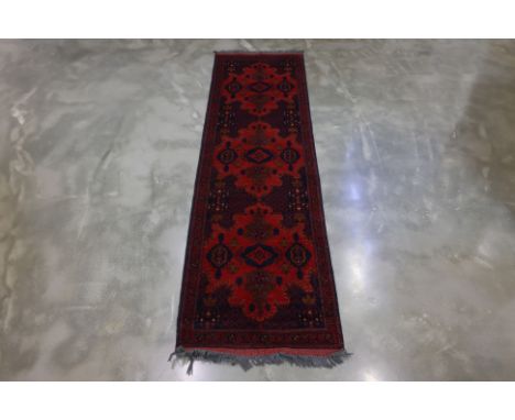 A MAZAR-I-SHARIF WOOL RUNNER (297 x 85cm)
Afghanistan, wool pile on wool base, red ground with three medallions
Ownership Sta