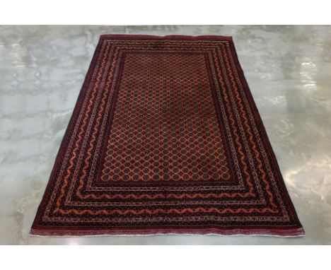 A KHAWAJA ROSHNAI WOOL CARPET (298 x 198cm)
Hand knotted, deep burgundy field with and allover design of guls, within multipl