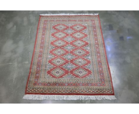 A KASHMIRI SILK AND WOOL RUG ( 175 x 125cm)
Hand knotted wool pile with a red field adorned with rows of diamond-shaped Tekke