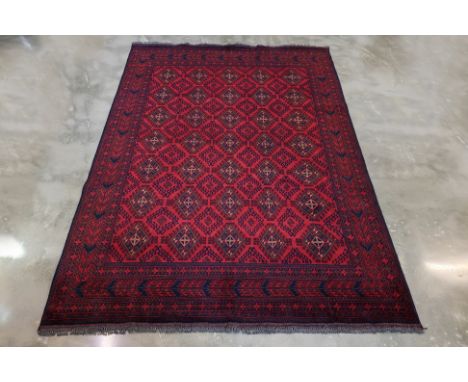 A TURKMAN WOOL RUG (288 x 210cm)
Hand knotted wool pile with  geometric diamond motifs in red and navy, bordered by intricate