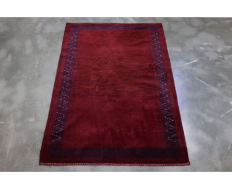 A CONTEMPORARY ZOLLANVARI WOOL RUG (190 x 123cm)
Hand knotted wool pile with a deep crimson field and a tonal border with geo