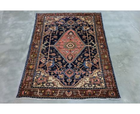 AN ANTIQUE PERSIAN MALAYER WOOL RUG (190 x 128cm) Hand knotted wool, navy field, with a large central pink medallion, geometr
