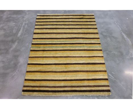 A CONTEMPORARY STRIPED WOOL RUG (182 x 122cm)
Hand knotted wool pile, striped design in yellow, ochre and brown tones
Ownersh