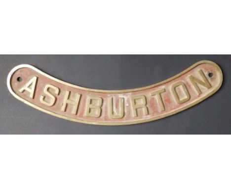 An old brass engine plate, of upwardly curved shape – 'Ashburton', remains of red paint in background around the raised lette