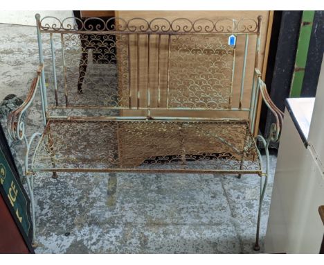 A green painted metal garden bench decorated with scrolled handles, wirework seat and back with tubular finials Location: 