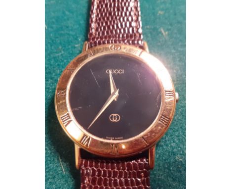 Gucci- A 1980/90's 3000M black dial and gold plated wristwatch having a brown leather strap in a snakeskin effect, serial num