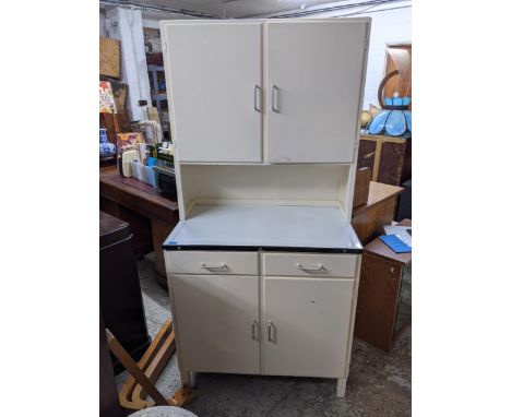 A 1950s/60s painted kitchen cabinet with a shelved interior, two top doors, an enamel work surface, the bottom section with t