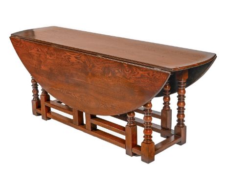 A Victorian oak double gateleg table, on turned baluster legs and stretcher base, 66cm h; 198 x 151cm fully extended Top surf