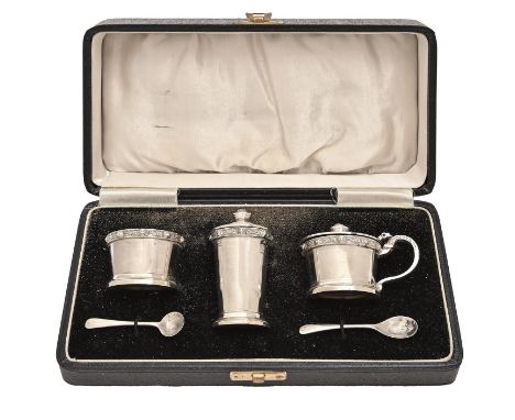 A George VI three piece silver condiment set, with borders of Celtic strapwork, blue glass liners, pepperette 65mm h, cased, 