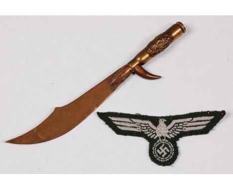 A WW II German army breast eagle, together with a trench art paper knife. (2)