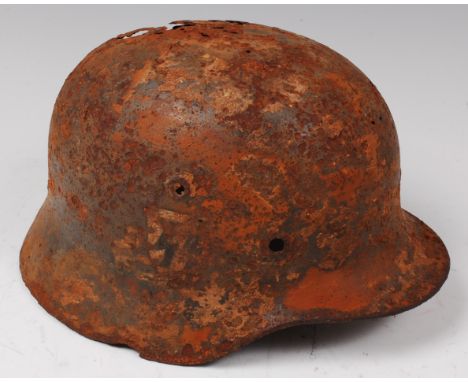 A German model 1935 steel helmet with remains of SS decal.