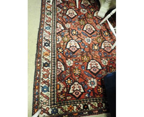 A Persian qashgai rug, the all over tribal design on a ruby ground within a floral repeating designed ivory border (AF) 300cm