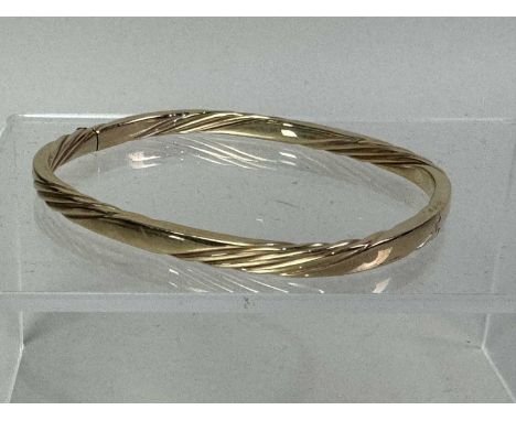 GOLD BANGLE, IN NINE CARAT GOLD with twist design, marked for nine carat gold6.5cm wideQty: 9.61g