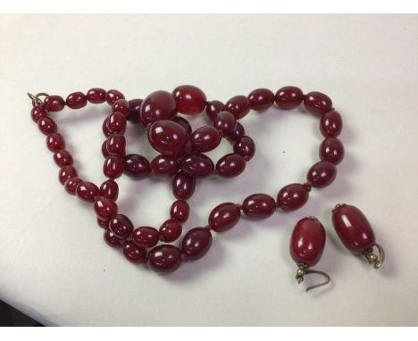 CHERRY AMBER COLOURED NECKLACE AND MATCHING EARRINGS, the necklace formed of graduated beadsthe largest bead 3cm wideQty: 234