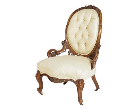A Victorian walnut nursing chair, with a carved and moulded frame with later fabric on cabriole legs and ceramic castors.