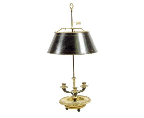 A Directoire gilt and patinated bronze bouillotte lamp, with an adjustable tole shade, the leaf cast stem with three branches