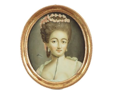 A Chinese reverse glass oval portrait painting, of an English lady, wearing a coral cloth and pearl headdress, late 18th / ea