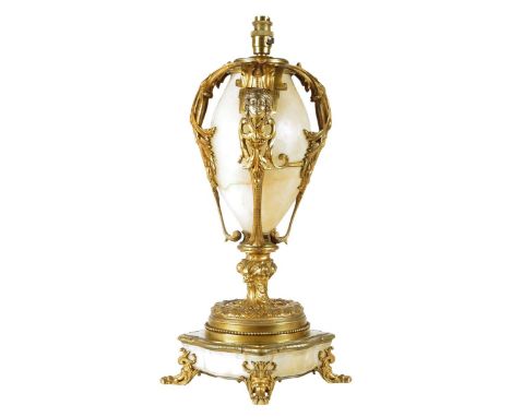 A late 19th century French gilt brass and alabaster lamp base, the ovoid body applied with leaf scroll and female mask mounts