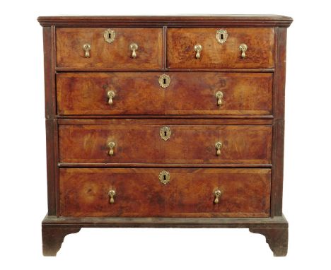 An early 18th century walnut chest, in two halves of two short and three long graduated burr veneered drawers, on bracket fee