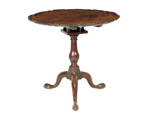 An early George III mahogany tripod table, the circular tilt-top with a piecrust edge, revolving on a birdcage, above a balus