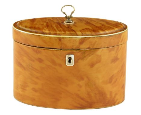 λ A George III blond tortoiseshell oval tea caddy, inlaid with ivory edging, the moulded hinged lid with a brass handle revea