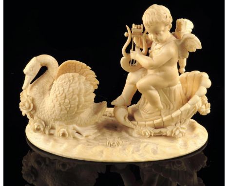 A European carved ivory group of Cupid and a swan,  seated in a flower festooned shell playing his lyre, drawn by a swan on a