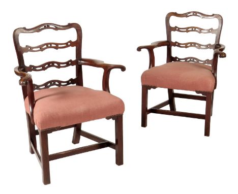 A pair of 19th century mahogany open armchairs, each with a pierced serpentine ladder back, above a pair of out-scrolling arm