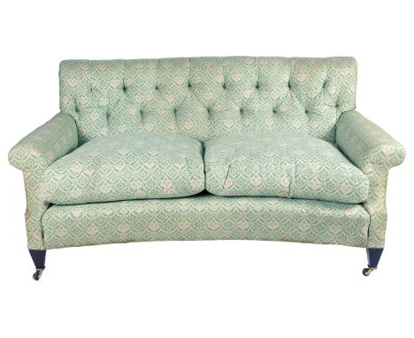 A Lenygon & Morant 'Howard' two seater sofa, with a button back and a concave front, with loose covers and 'H & S' monogramme
