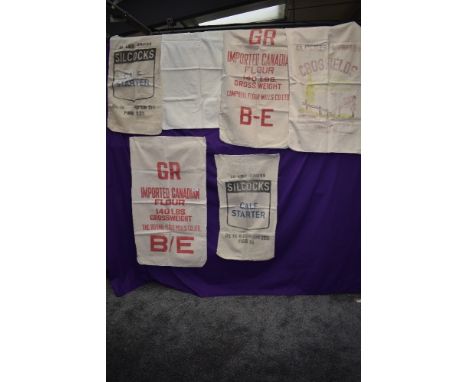 Seven vintage printed flour and feed sacks.