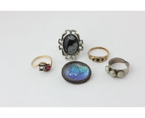 A ruby ring, a sapphire ring, two base metal rings, and a butterfly wing brooch