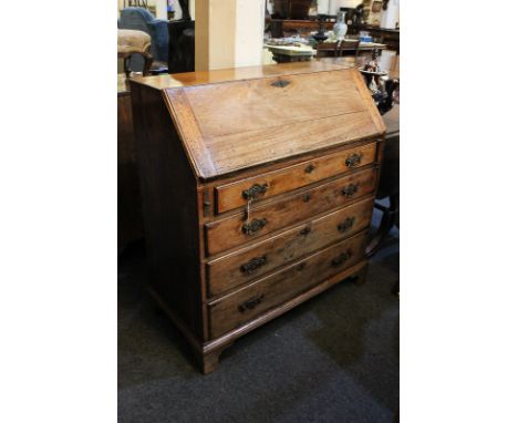 A George III mahogany bureau, the fall front enclosing fitted interior of seven small drawers and pigeon holes, above four dr