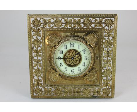 A late 19th century brass framed timepiece with square shaped frame decorated with scallop shells within a pierced border of 