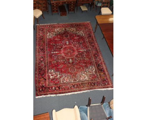 A Turkish wool carpet, with central geometric design within multi line border, on red ground, 247cm by 326cm