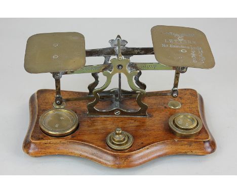 A set of brass postal scales with six weights