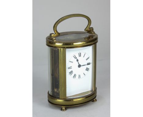 A brass cased oval carriage clock, the white enamel dial with Roman numerals, the movement stamped France, 11.5cm high, with 