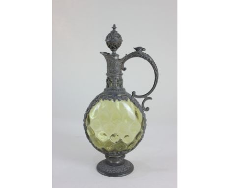 A Continental metal mounted green glass flask with stopper with mask head and pierced scrolling design, 26cm high