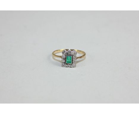 An emerald and diamond ring, the step cut stone in a border of ten eight-cut diamonds