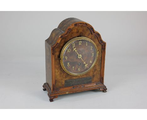 An early 20th century walnut veneered mantel clock, retailed by Russells of Manchester, in shaped case with carved border, th