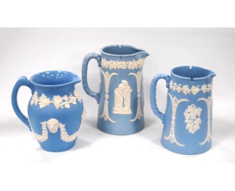 Three Dudson Pottery blue Jasper ware jugs in 'Figures and Divisions', 'Wheatsheaf and Hops' and 'Festoon' pattern, 17cm, 15c
