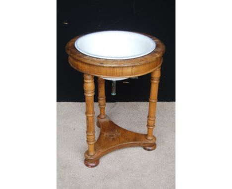 19th century oak circular washstand enclosing basin, raised on ring turned legs, triform base and bun feet, 38cm diameter and